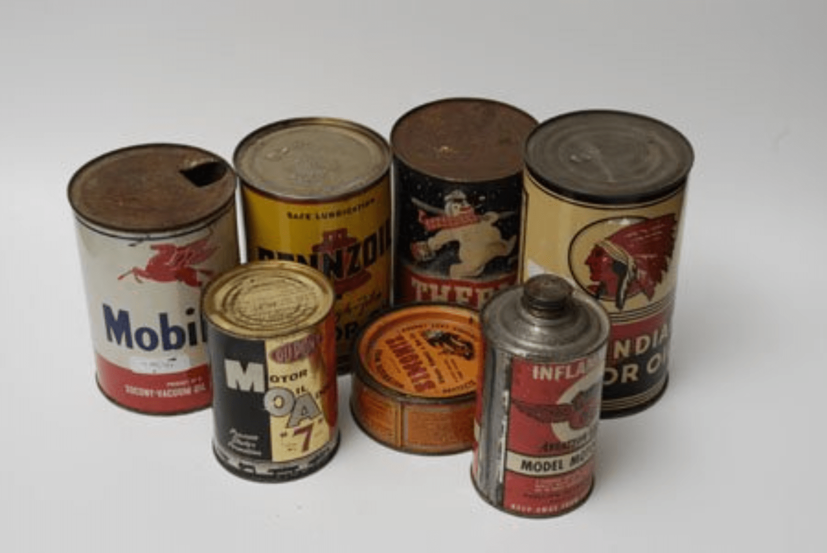Sept bidons d'huile en tôle lithographiée