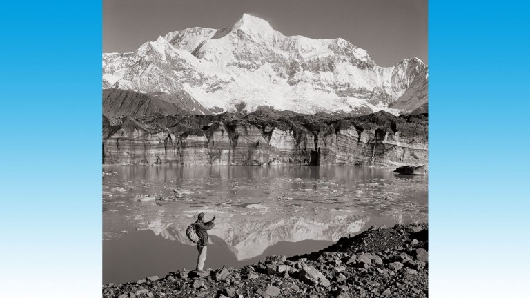 Un explorateur BP, debout près d'un lac glaciaire, lors d'un relevé en Alaska, 1961.